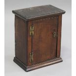 An 18th century oak spice cupboard, the single door enclosing a drawer and a shelf, height 44cm,