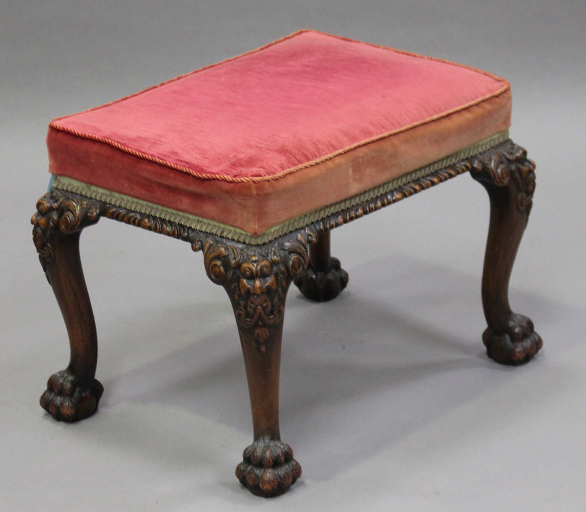 An early 20th century George II style stained walnut stool, the overstuffed seat upholstered in pale