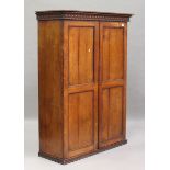 A 19th century rosewood wardrobe, probably colonial, the guilloche carved pediment above a pair of