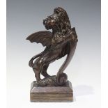 An 18th/19th century carved oak heraldic winged lion, modelled on its hind legs, mounted on a