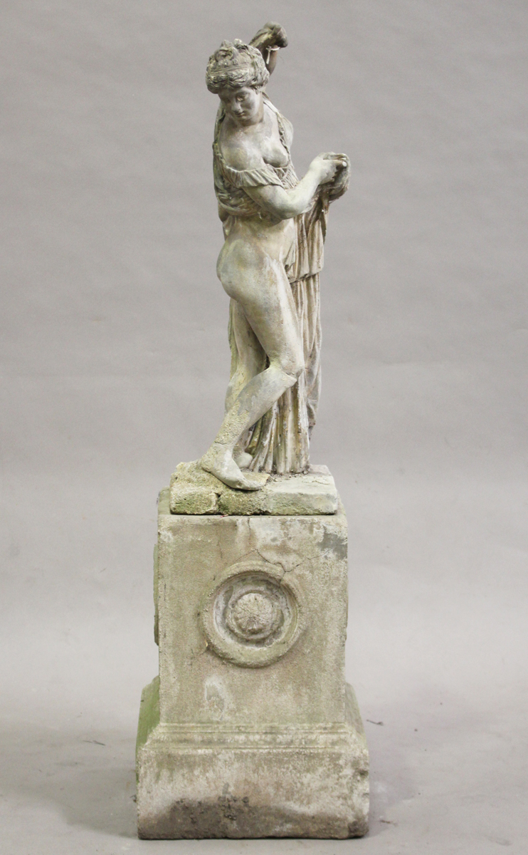 An early 20th century cast composition stone garden figure of a classical bathing maiden, raised