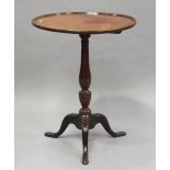 A late George III mahogany wine table with raised rim, on a turned baluster column and tripod