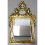 A late 20th century giltwood sectional wall mirror, the shaped pediment inset with two mirrored