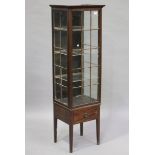 An Edwardian mahogany narrow display cabinet, fitted with a single glazed door, raised on an