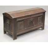 An 18th century oak coffer, the domed three-plank lid above a carved panel front, the interior