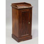 An early Victorian figured mahogany bedside cabinet, fitted with a panel door, on a plinth base,