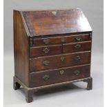 A George III oak bureau, the fall flap revealing a stepped interior with cupboard, pigeonholes and