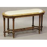 A 20th century French walnut stool, the overstuffed seat raised on fluted legs united by a shaped