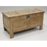 A late 17th century oak coffer, the hinged lid with wire hinges, the front with later carved