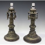 A pair of 20th century Middle Eastern pierced brass table lamps, the inverted rims hung with deity