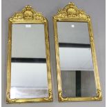 A pair of late 19th/early 20th century gilt composition pier mirrors, the arched frames cast with