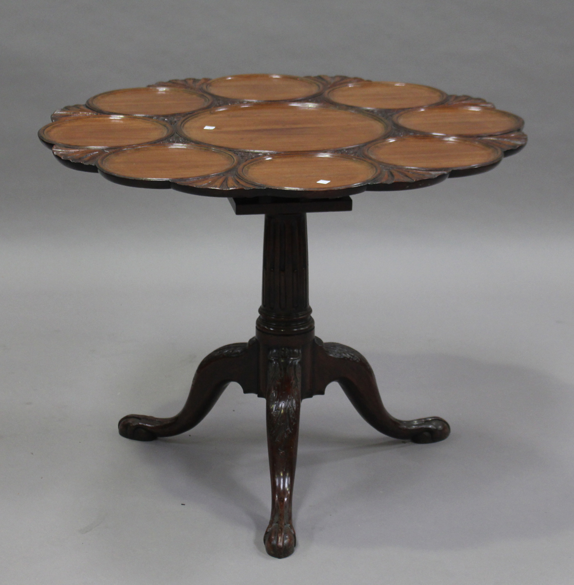 A George III mahogany tip-top supper table, the circular top later carved with nine roundels and