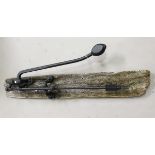 A 19th century cast iron wall mounted well pump with distressed wooden backplate, length 140cm.