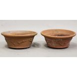 A pair of late 20th century terracotta circular planters, the sides moulded with bands of running