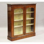 A Victorian mahogany glazed bookcase, the two arched panel doors enclosing adjustable shelves,