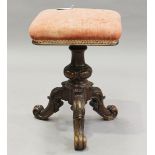 A mid-Victorian rosewood revolving piano stool, raised on carved tripod legs, height 49cm, width