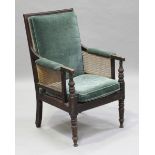 A Victorian mahogany showframe bergère library armchair, raised on ring turned legs, height 105cm,