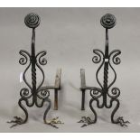 A pair of late Victorian Arts and Crafts style wrought iron fire andirons of scroll form, height