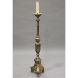 An early 20th century Baroque Revival silvered wood lamp standard with carved decoration, one side