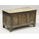 An early 18th century oak coffer, the hinged lid enclosing a candlebox, the front carved with