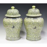A pair of modern Chinese yellow glazed vases and covers, enamelled in blue with dragons and scrolls,