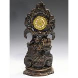 A 19th century Flemish oak watch stand, carved with rococo scrolls above a child filling a jug