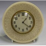 An Art Deco ivory circular cased bedside timepiece with eight day movement, the dial with Arabic