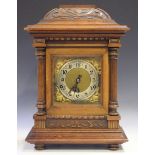 An early 20th century German walnut mantel clock with eight day movement chiming on gongs, the