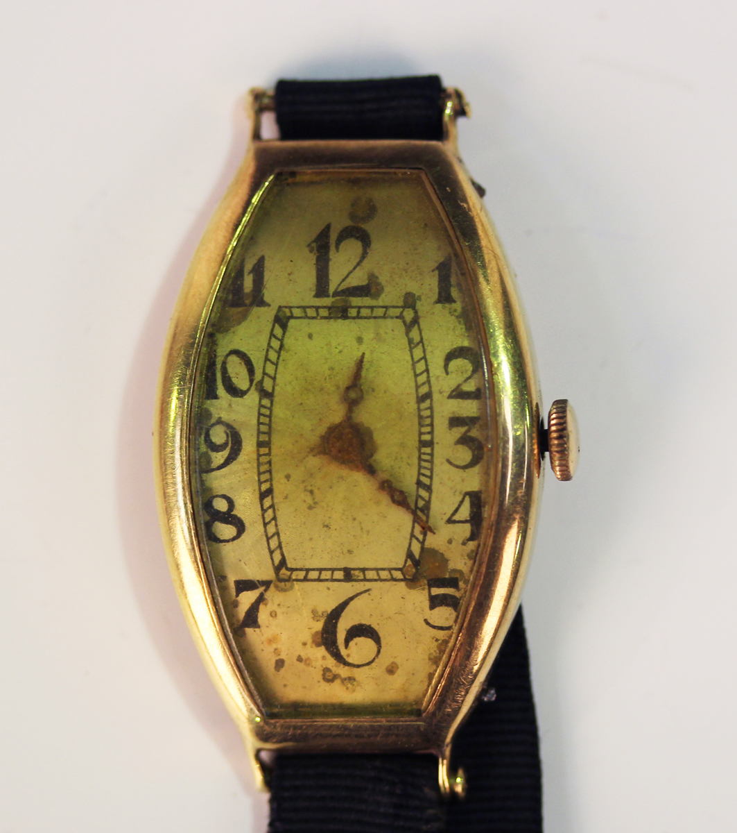 A gold curved rectangular cased wristwatch, the unsigned dial with black Arabic numerals, the case