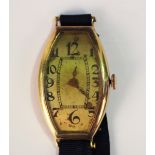 A gold curved rectangular cased wristwatch, the unsigned dial with black Arabic numerals, the case