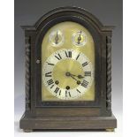 A George V oak mantel clock with eight day movement chiming on gongs, the gilt brass dial with