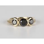 A 9ct gold ring, mounted with three circular cut black diamonds, ring size approx N1/2.Buyer’s