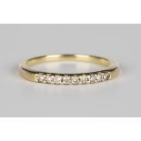 An 18ct gold ring, mounted with a row of nine circular cut diamonds, ring size approx N1/2.Buyer’s