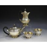 A George V silver four-piece tea set, each circular body cast with a foliate band, comprising