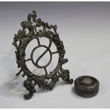 A late Victorian silver watch stand, the frame of rococo scroll moulded form with hinged strut