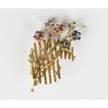 A gold, diamond, ruby, emerald and sapphire brooch in a floral spray multiple flowerhead design,