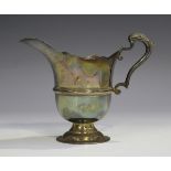 An Elizabeth II Irish silver cream jug of girdled 'U' shaped form with wavy rim and scroll handle,