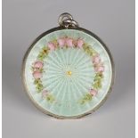 A silver and pale green enamelled circular pendant locket, decorated with a border of pink