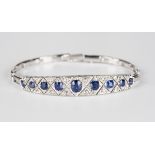 A white gold, sapphire and diamond bracelet, the front mounted with a row of nine graduated