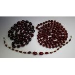 A reconstituted amber cherry coloured uniform oval bead necklace, length 118cm, another