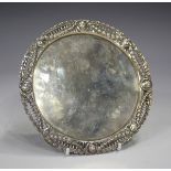 A late Victorian silver circular card salver, the cast rim pierced with portrait bust panels and