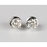 A pair of white gold and diamond single stone earstuds, each claw set with a circular cut diamond,