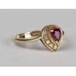 A 9ct gold, ruby and diamond cluster ring, mounted with a pear shaped ruby within a surround of nine
