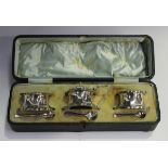 An Edwardian silver three-piece condiment set of shaped octagonal form, comprising a mustard and two