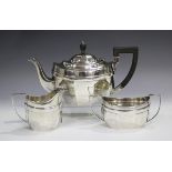 A George V silver three-piece tea set of faceted oval form, comprising teapot, two-handled sugar