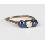 A gold and silver set, diamond, sapphire and blue gem set three stone ring, mounted with the cushion