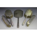 A George V silver five-piece dressing table set, comprising a hand mirror, a pair of hairbrushes and