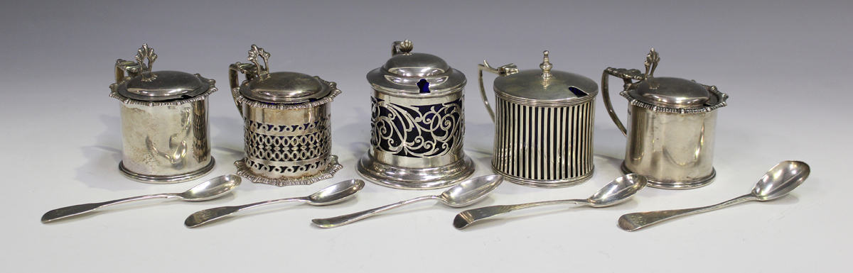 A pair of George V silver cylindrical mustards with hinged lids and blue glass liners, Sheffield