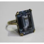 A gold ring, claw set with a large cut cornered rectangular step cut synthetic blue spinel, detailed