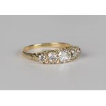 A gold and diamond five stone ring, claw set with a row of circular cut diamonds graduating to the